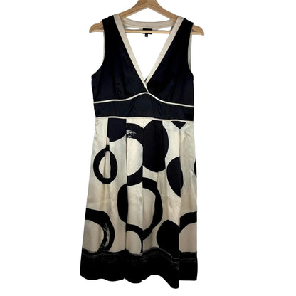 Black and white patterned dress on a hanger against a plain background