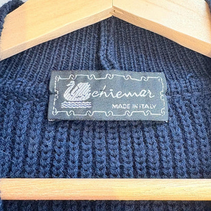 Blue knitted sweater with a label on a wooden hanger