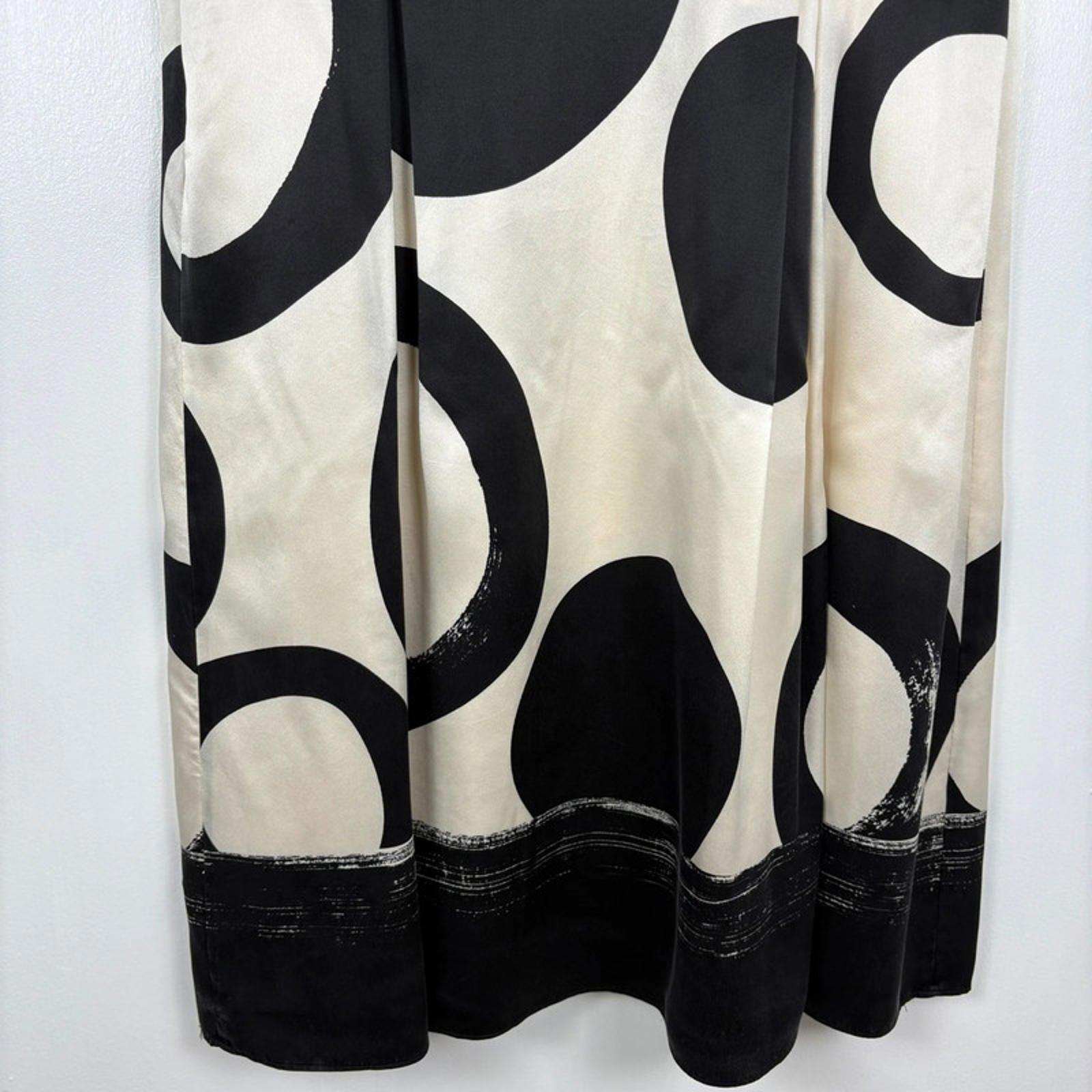 Close up of Dress bottom with black and white circular pattern on a plain background