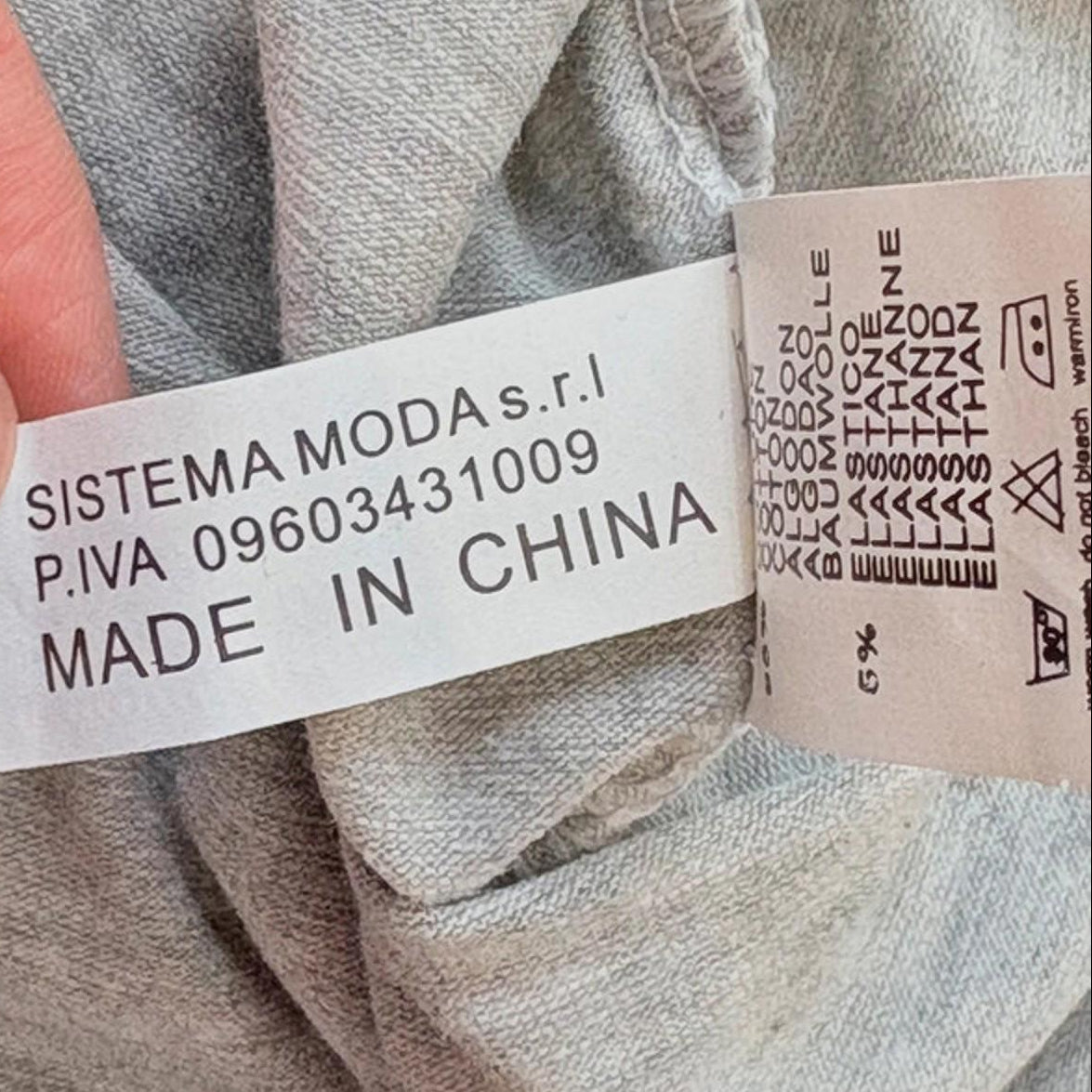 Fabric with a 'Made in China' label held by a hand