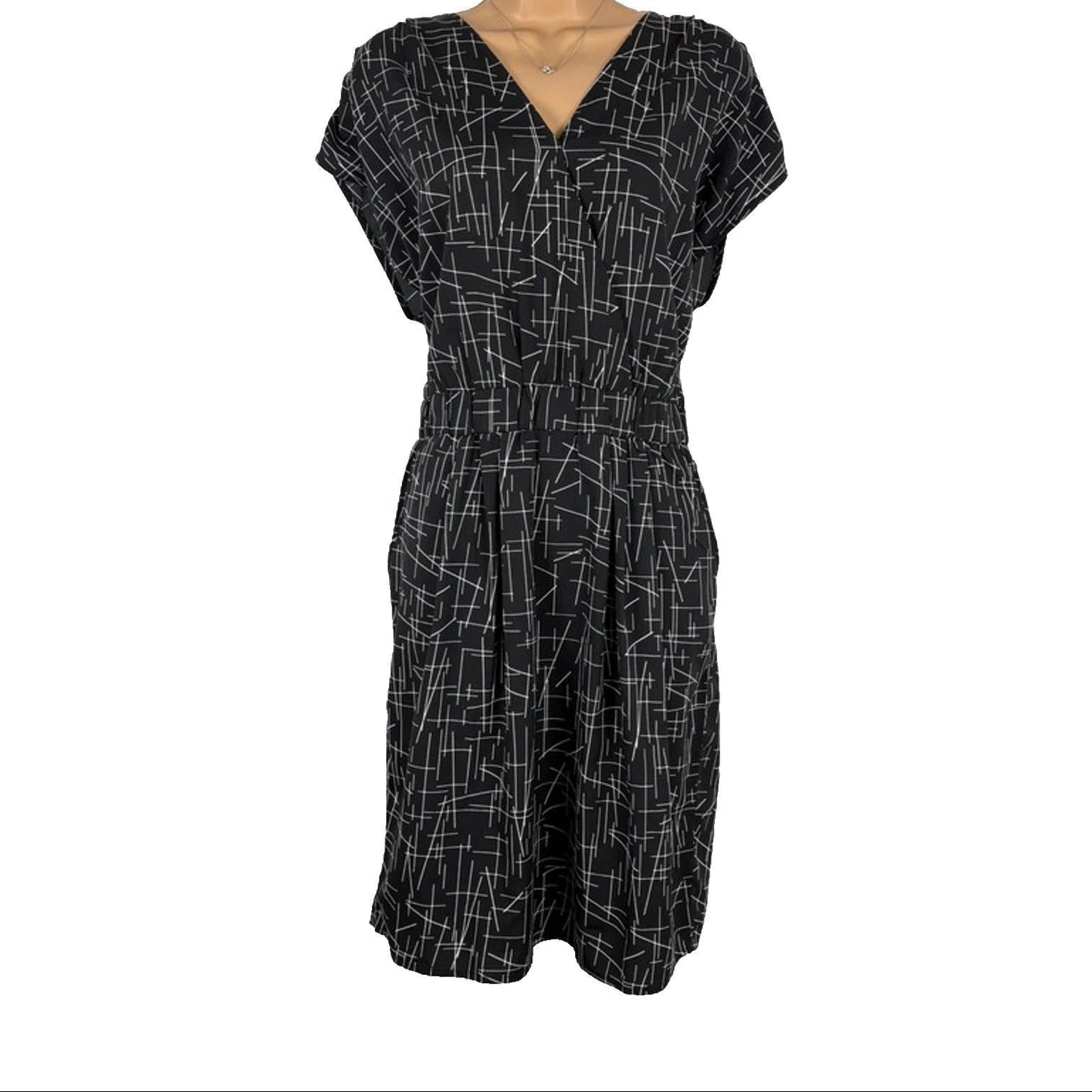 Black dress with white geometric pattern on a mannequin against a white background