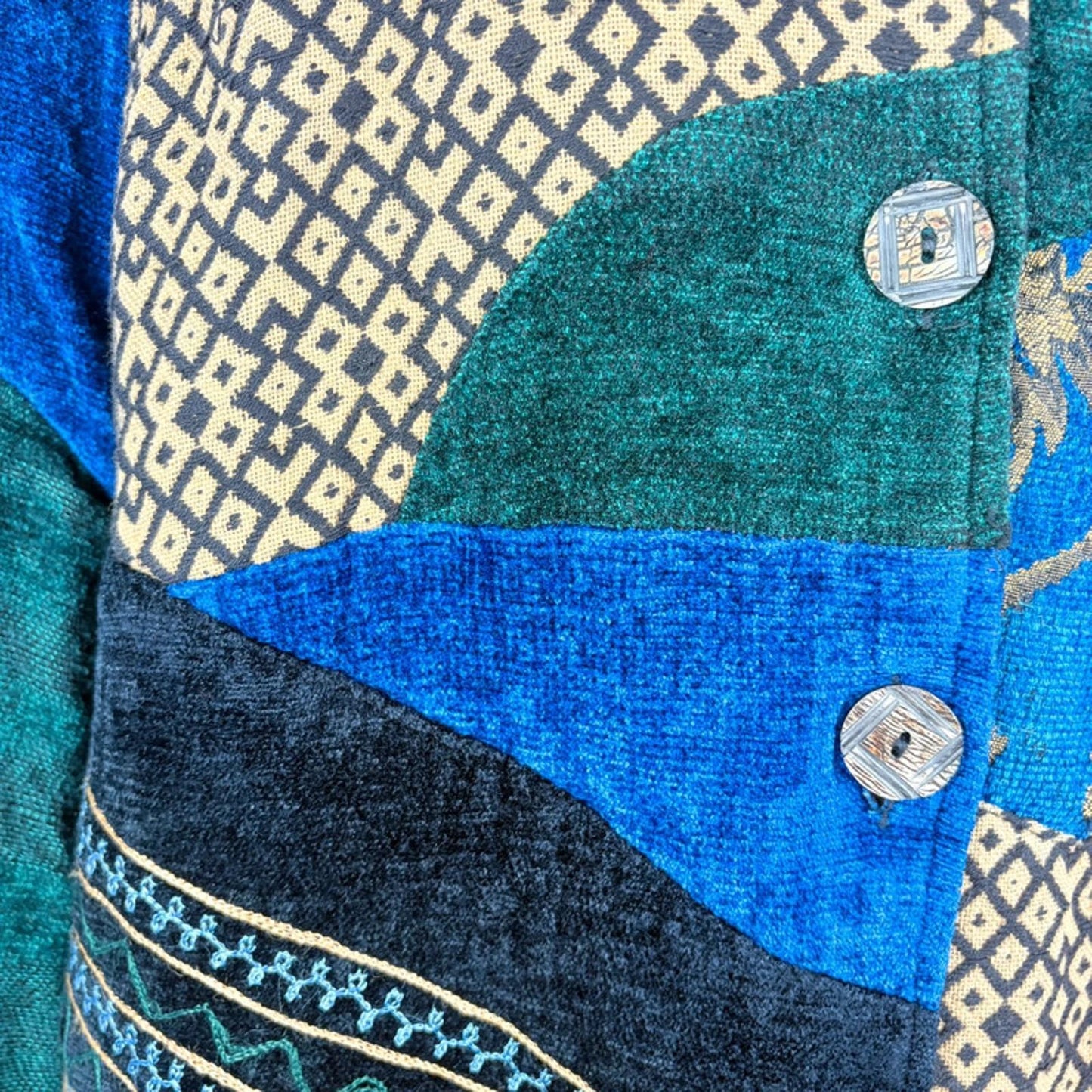 Close-up of a textured fabric with geometric patterns and buttons.