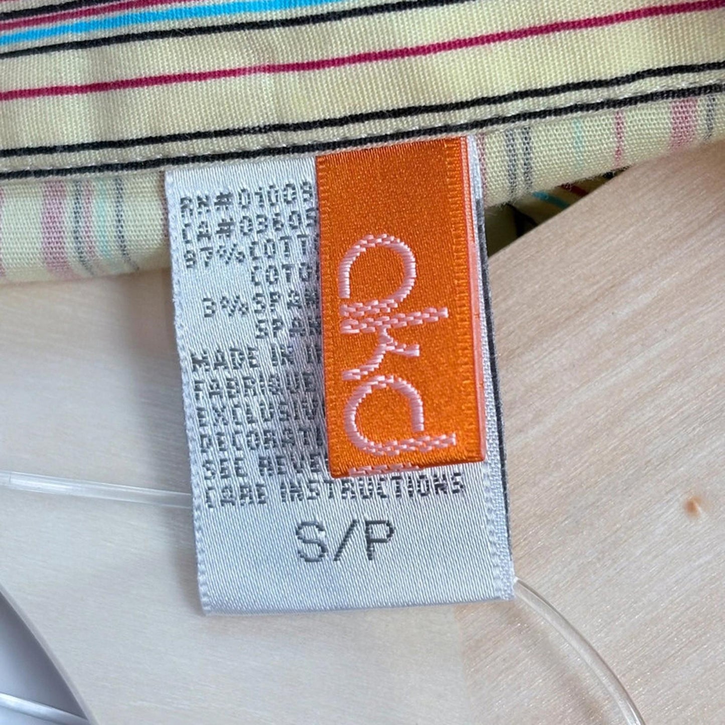 Fabric tag with brand name on a striped fabric background