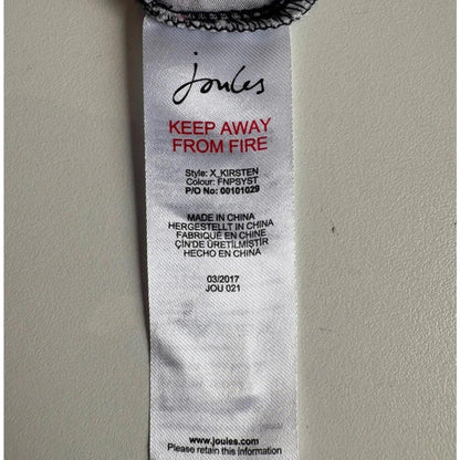 Close-up of a label on a garment with 'Joules' branding and fire safety instructions.