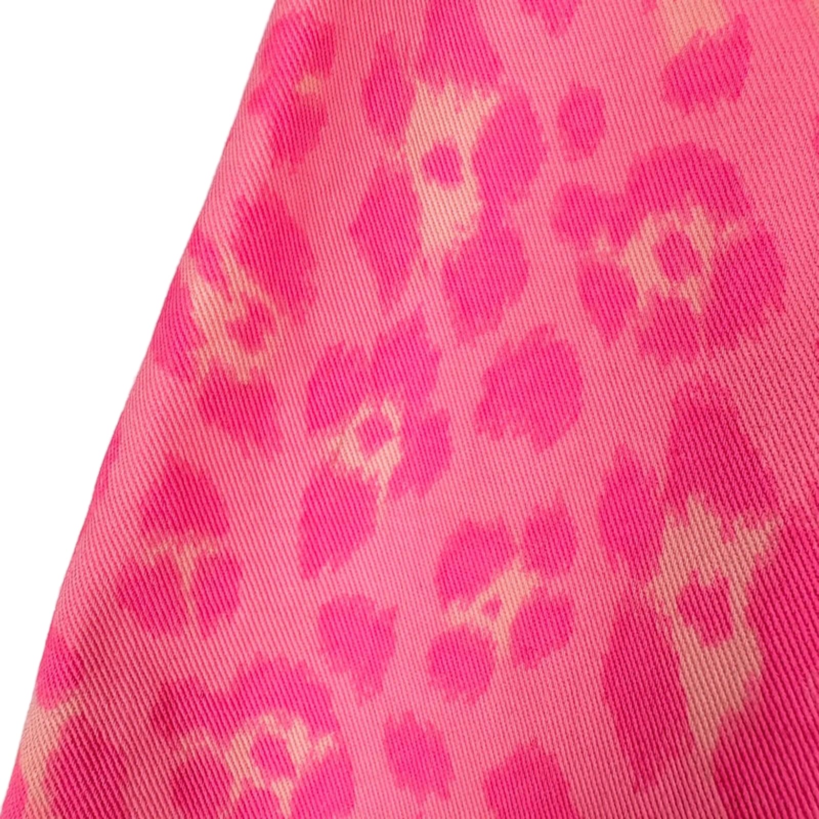 Close-up of pink fabric with a leopard print pattern on a white background