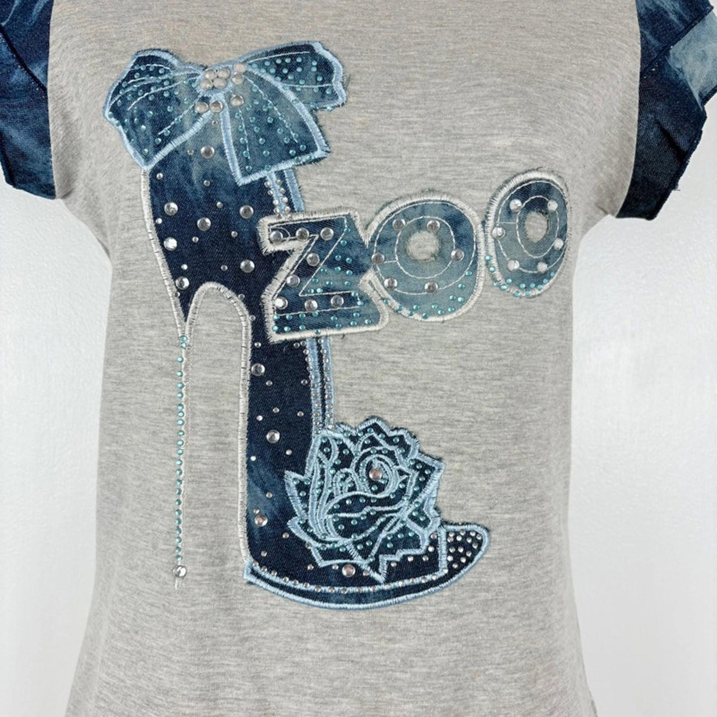 Gray shirt with decorative elements including a bow, 'Zoo' text, and rose design on a white background