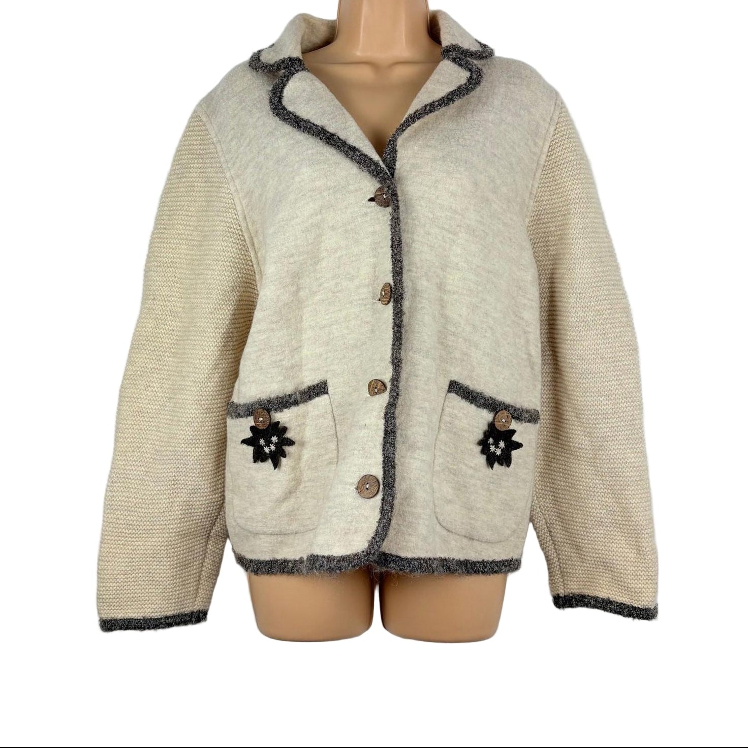 Beige knitted jacket with dark trim on a mannequin against a white background