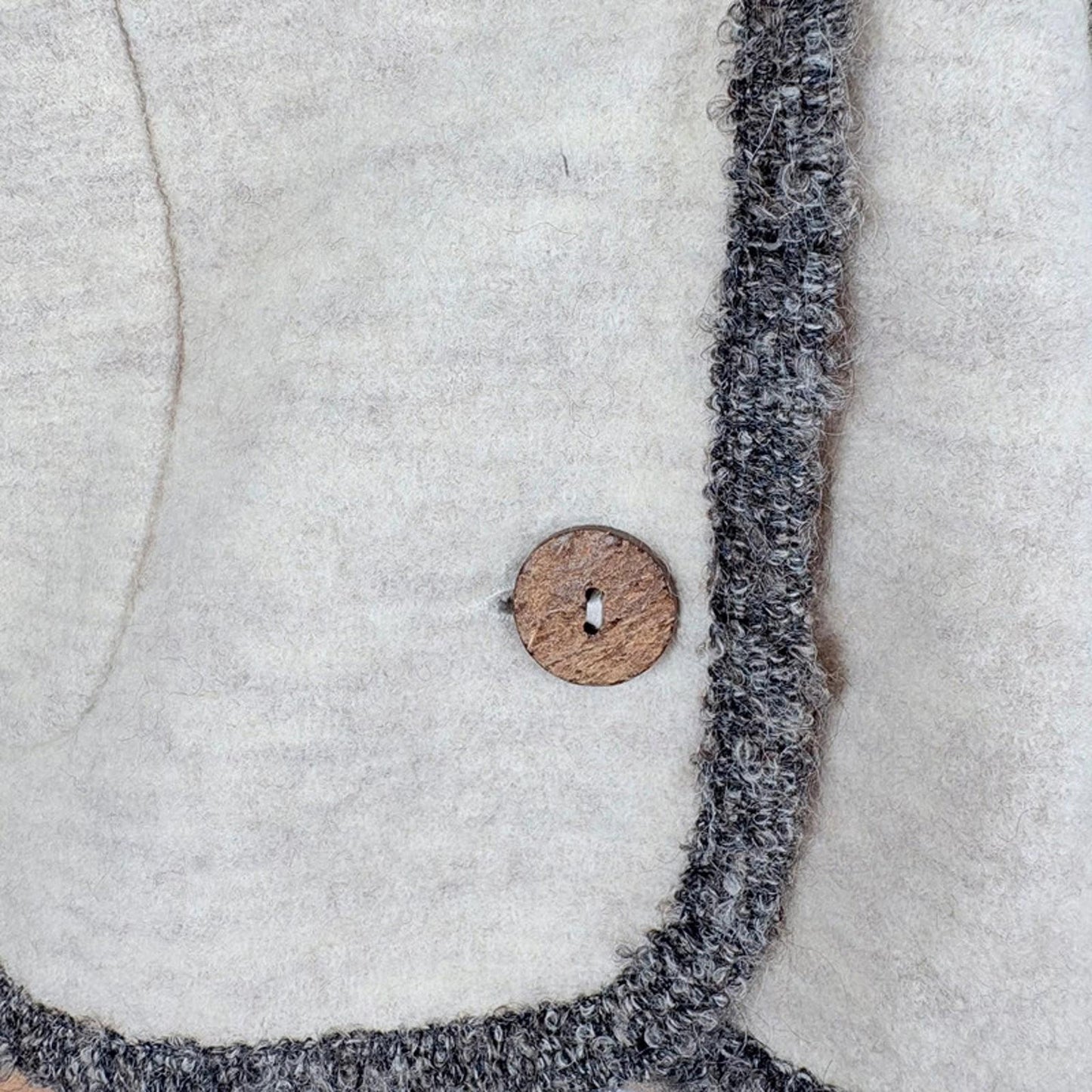 Close-up of a textured fabric edge with a wooden button 