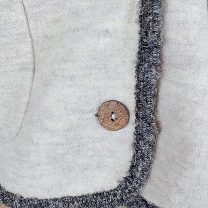 Close-up of a textured fabric edge with a wooden button 