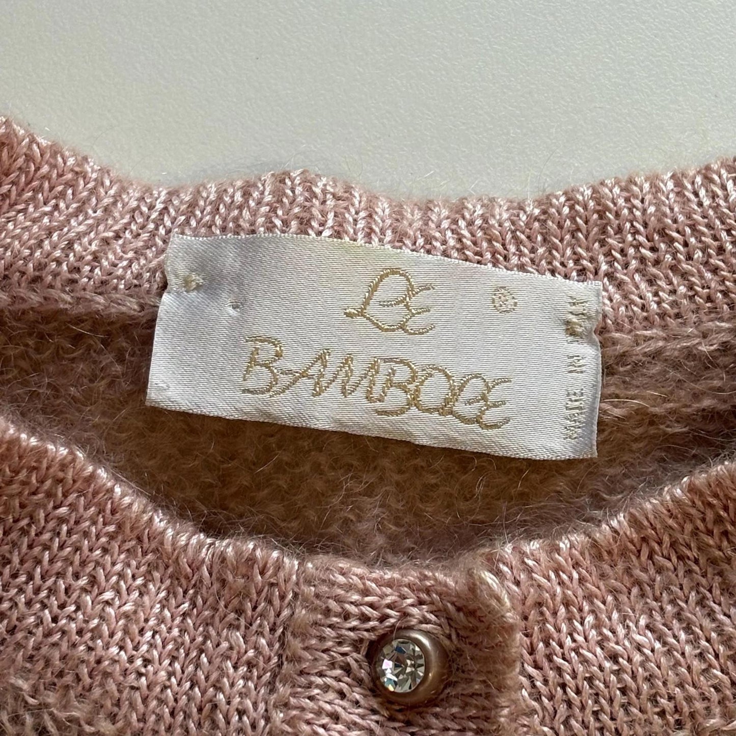 Close-up of a pink textured fabric with a 'Le Bambole' label.