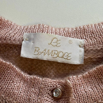 Close-up of a pink textured fabric with a 'Le Bambole' label.