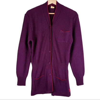 Purple cardigan with red trim on a white background