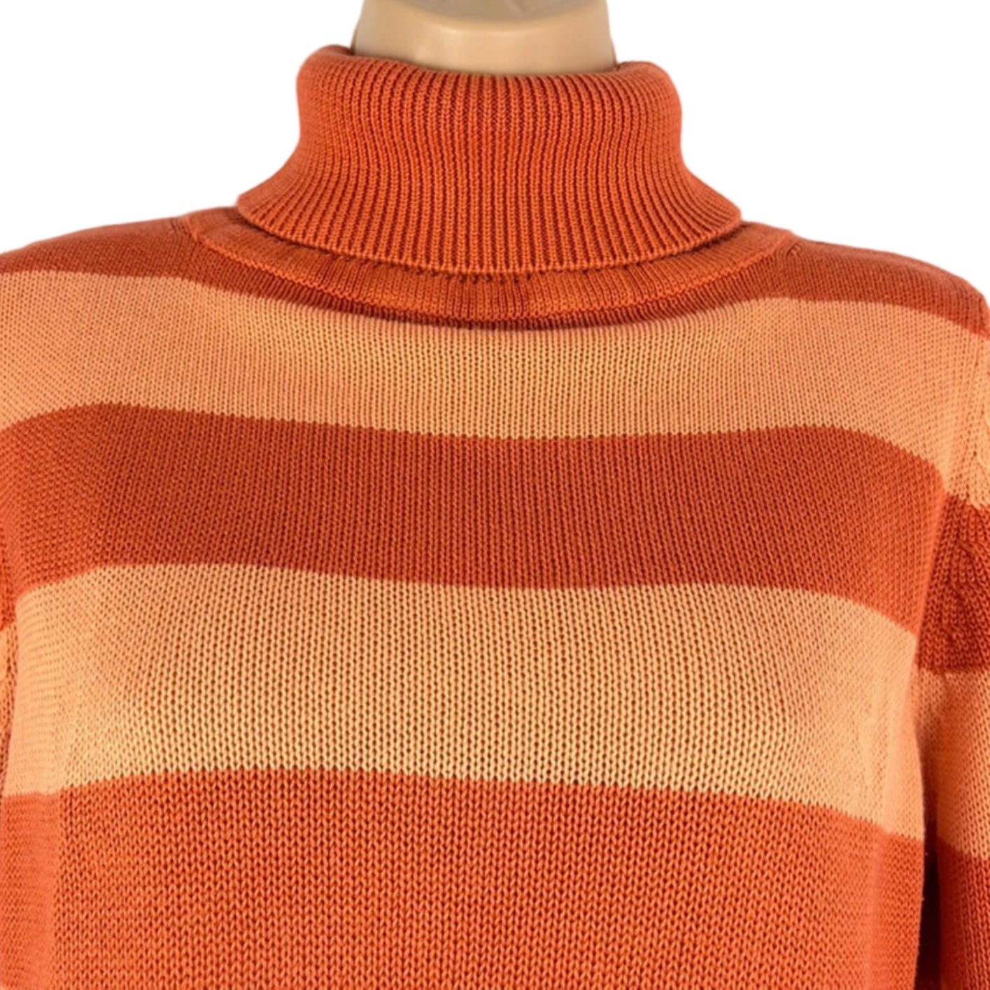 Orange and beige striped sweater on a mannequin against a white background