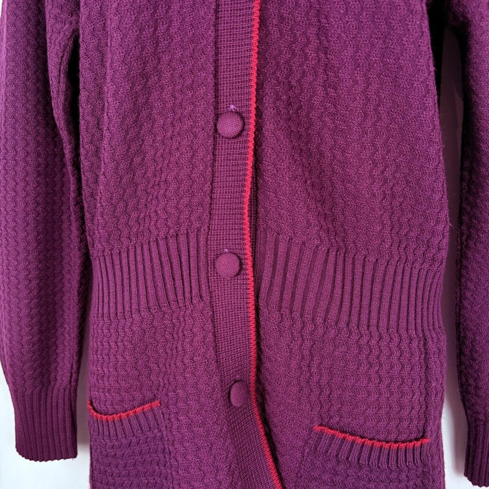 Close-up of a purple knitted cardigan with buttons on a white background