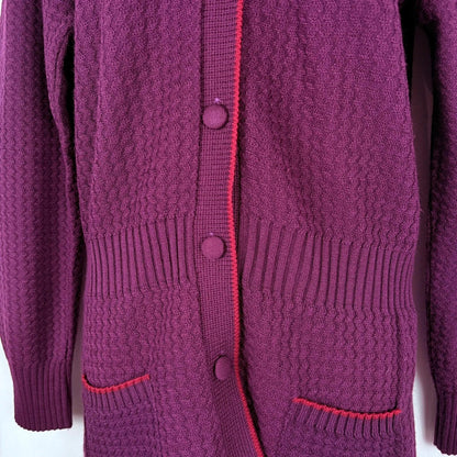 Close-up of a purple knitted cardigan with buttons on a white background