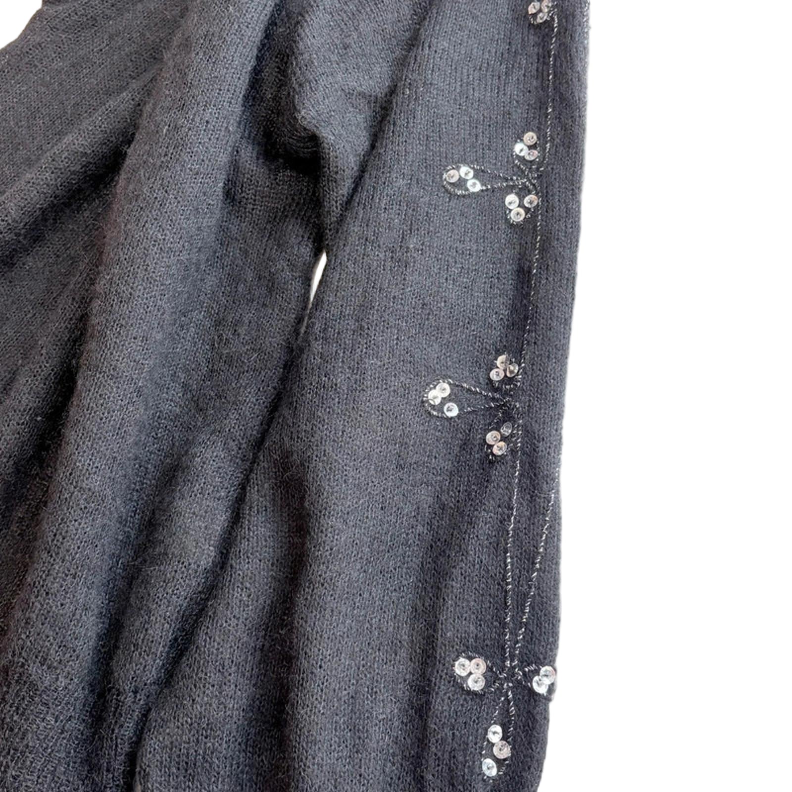 Black fabric with small white floral embellishments on a white background