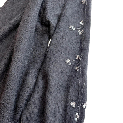 Black fabric with small white floral embellishments on a white background