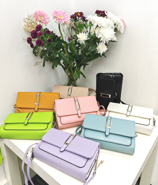 Colorful handbags on a table with flowers in the background