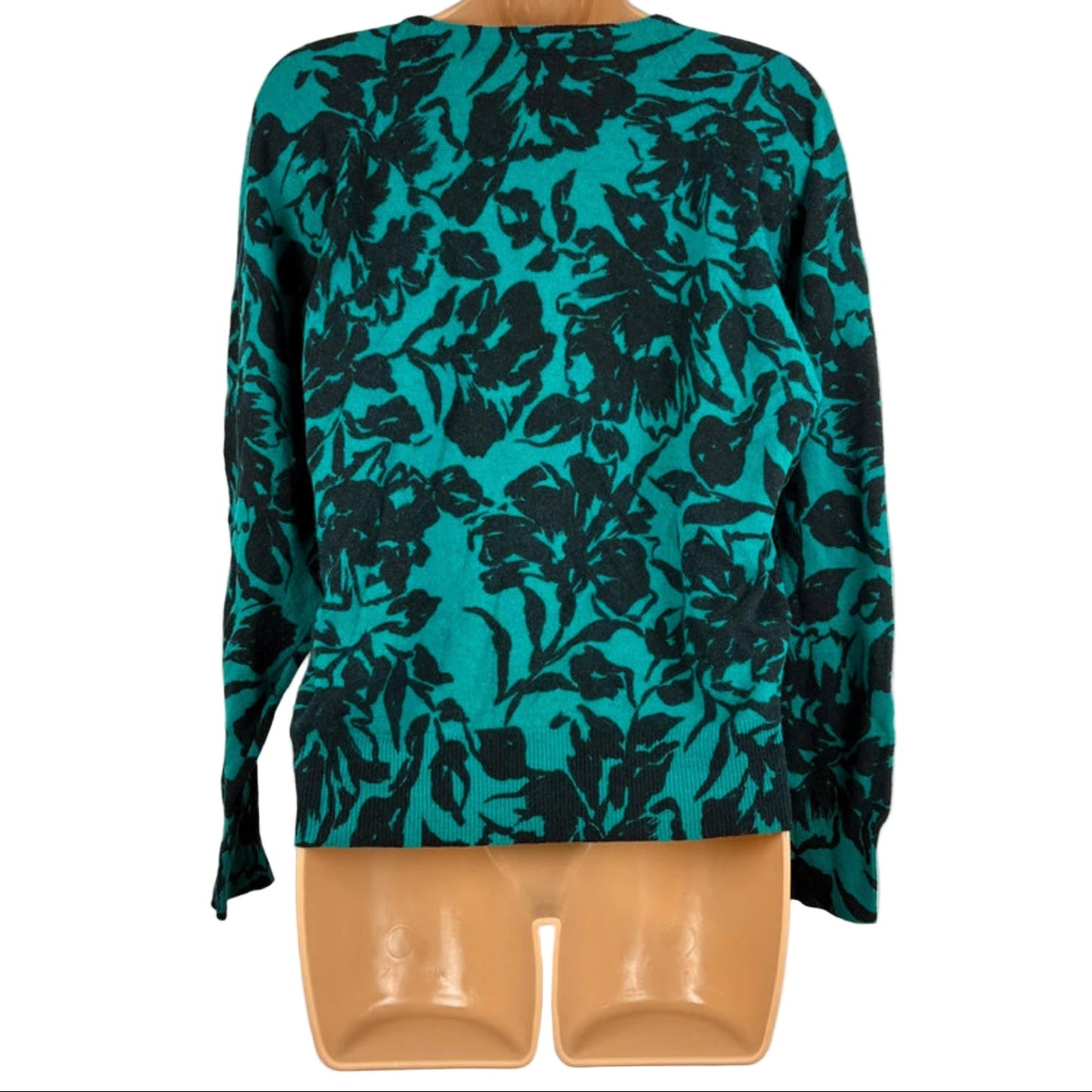 Teal floral patterned top on a mannequin against a white background