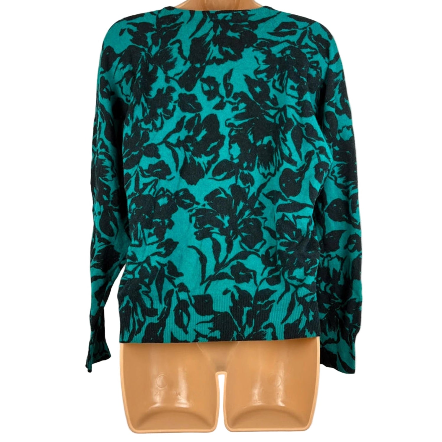 Teal floral patterned top on a mannequin against a white background