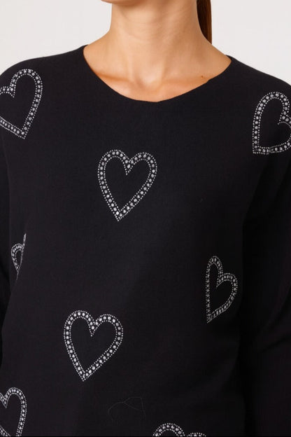 Black sweater with heart patterns on a plain background