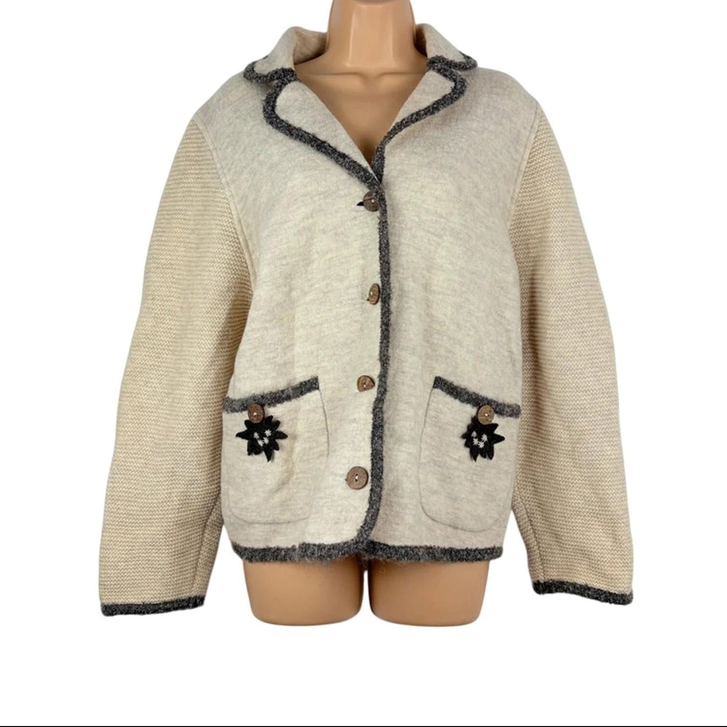 Beige knitted jacket with dark trim on a mannequin against a white background