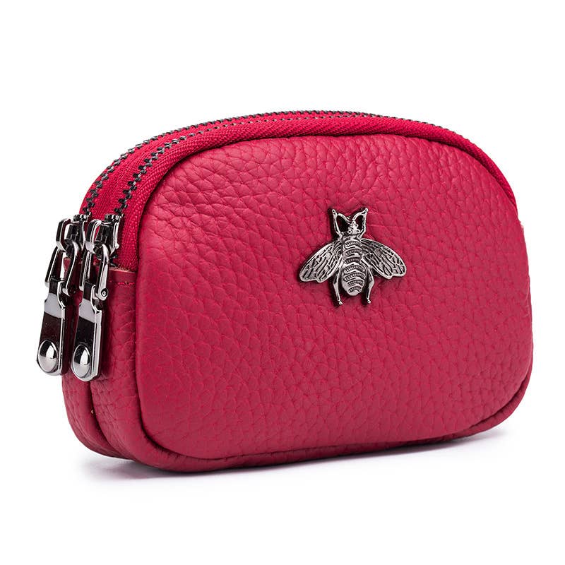 Red purse with a bee emblem and multiple zippers on a white background