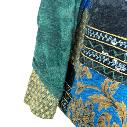 Close-up of green and blue fabric with intricate patterns on a white background