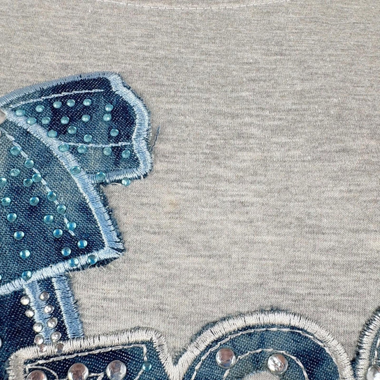 Close-up of a gray fabric with blue embroidered design