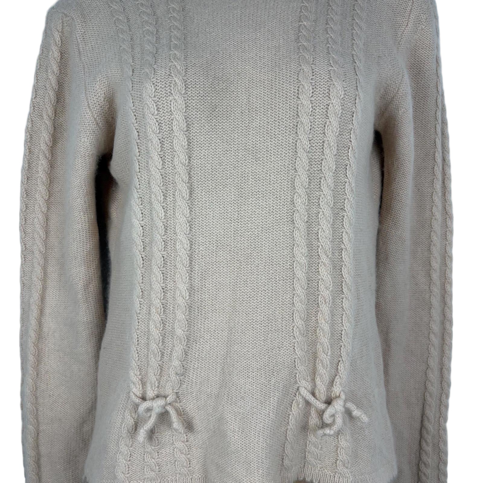 Close-up of a pink cable knit sweater on a white background