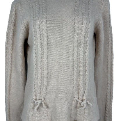 Close-up of a pink cable knit sweater on a white background