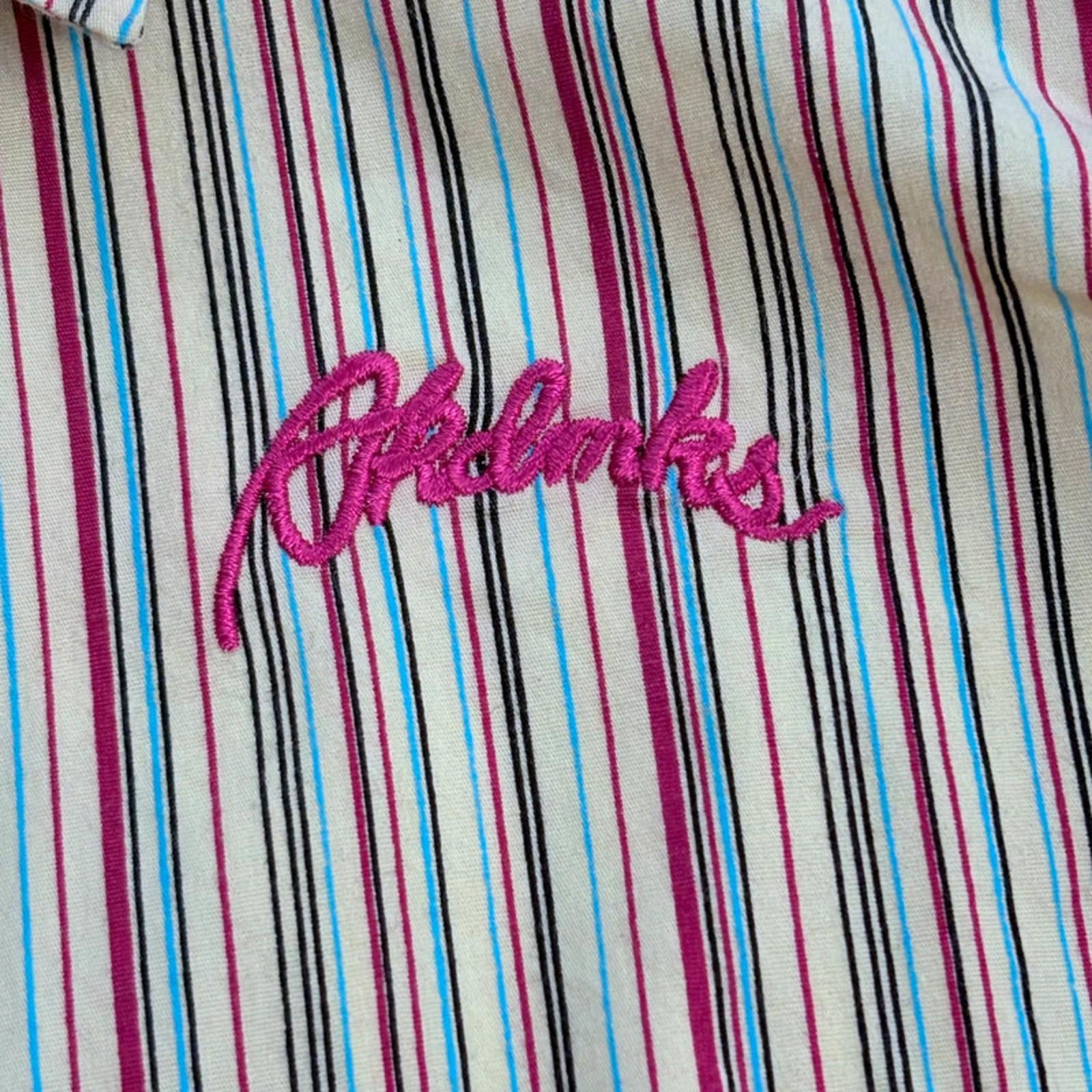Striped fabric with Akadmks embroidered in pink on a multicolored background