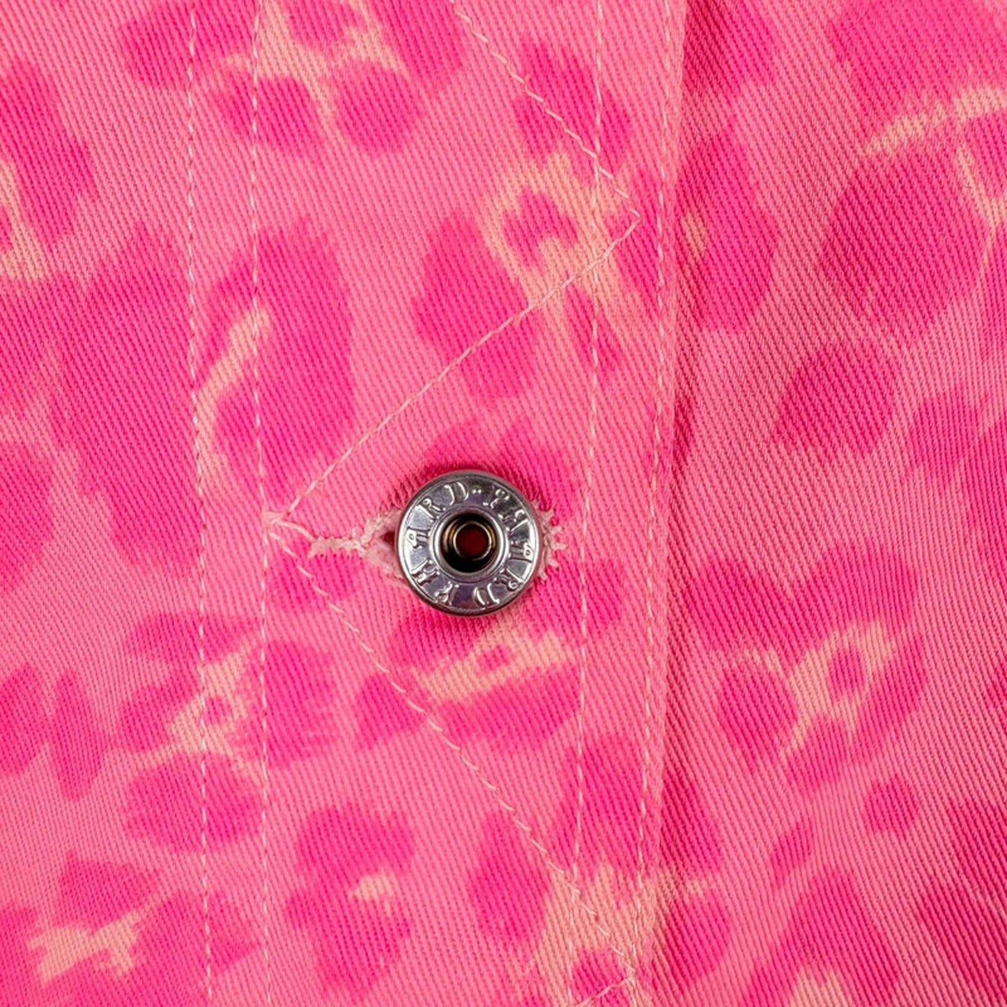 Close-up of a pink floral shirt with a button