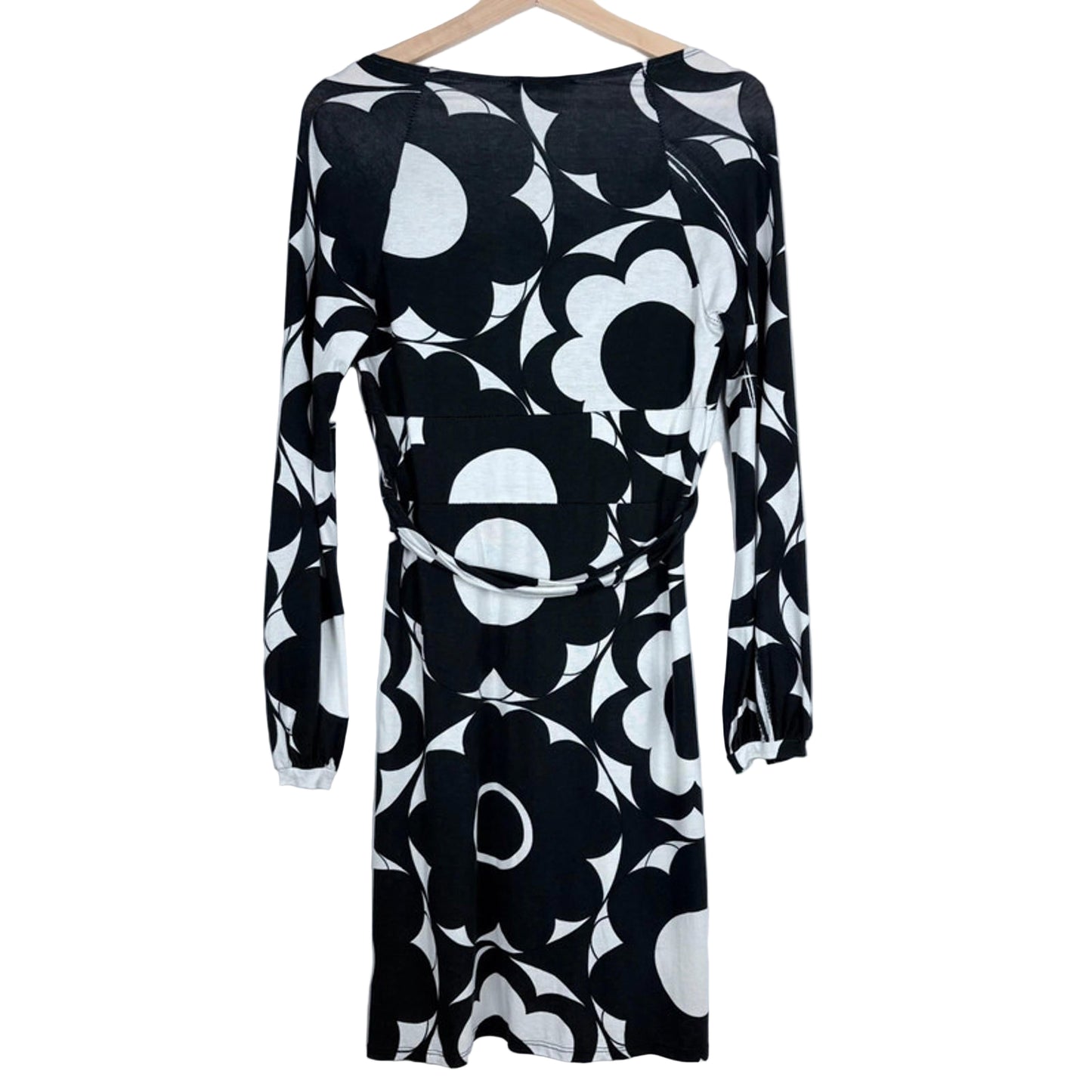 Black and white floral patterned dress on a hanger against a light gray background