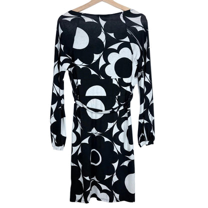 Black and white floral patterned dress on a hanger against a light gray background