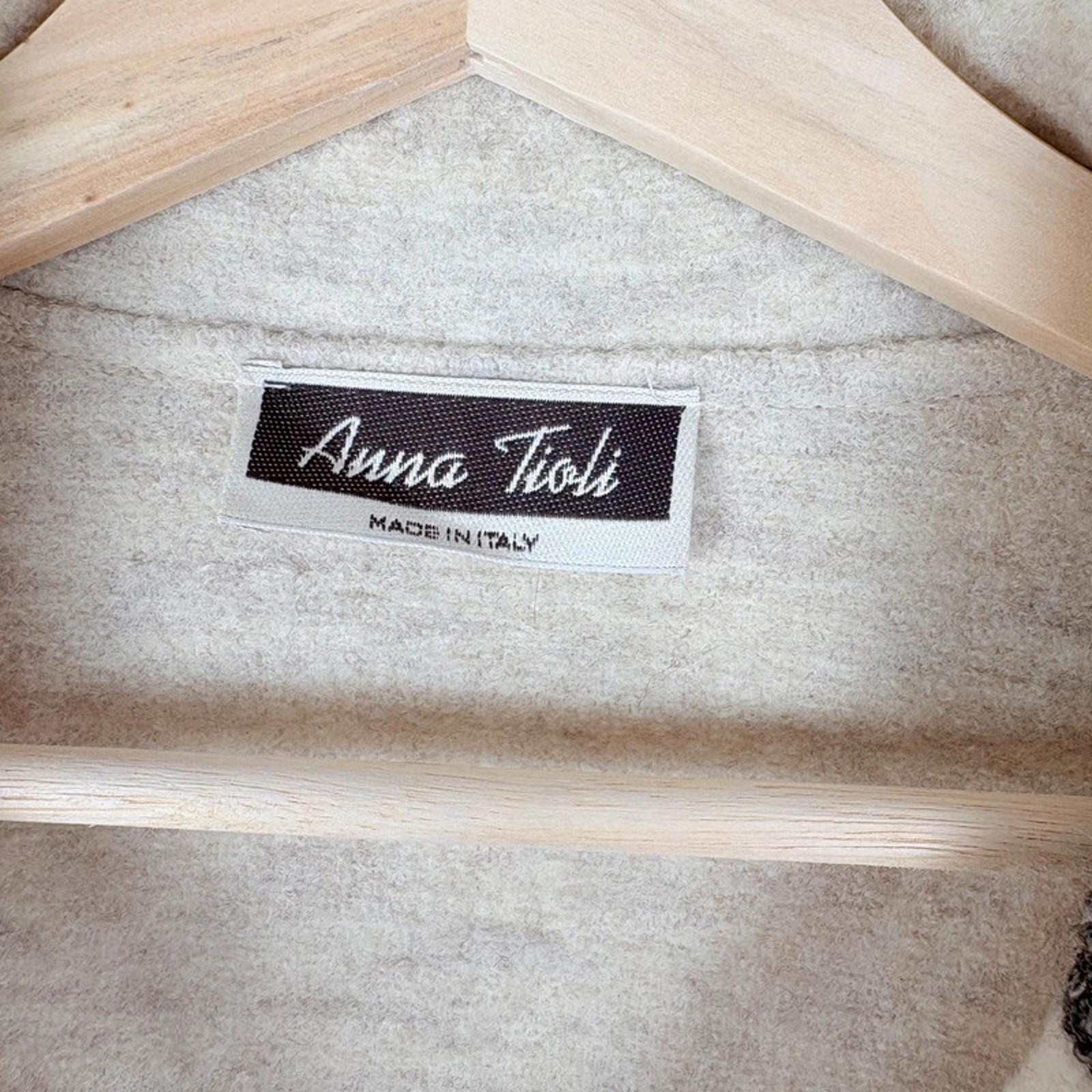 Label with 'Anna Tioli' branding on a textured fabric background