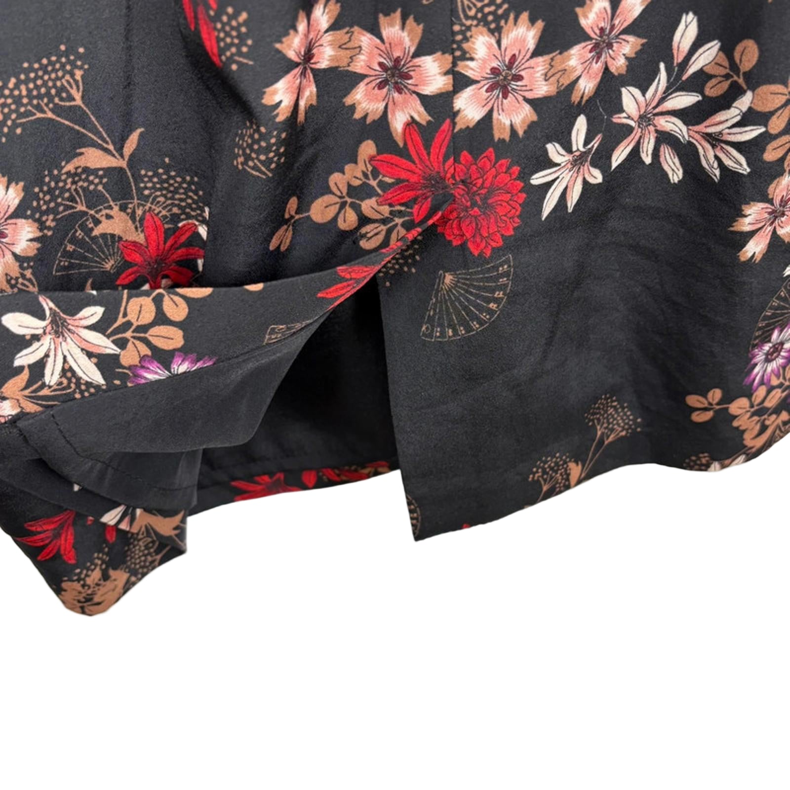 Floral patterned fabric with red and pink flowers on a black background