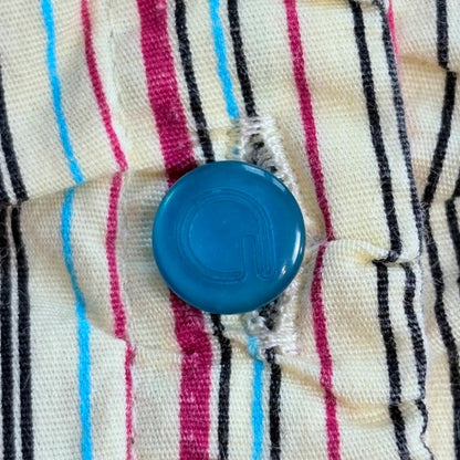Blue button on a striped fabric background