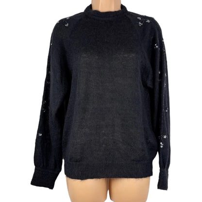 Black sweater with decorative sequins on a mannequin against a white background