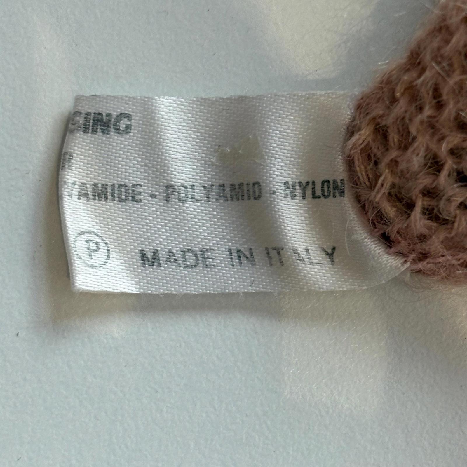 Fabric tag with material information and 'Made in Italy' on a textured surface.