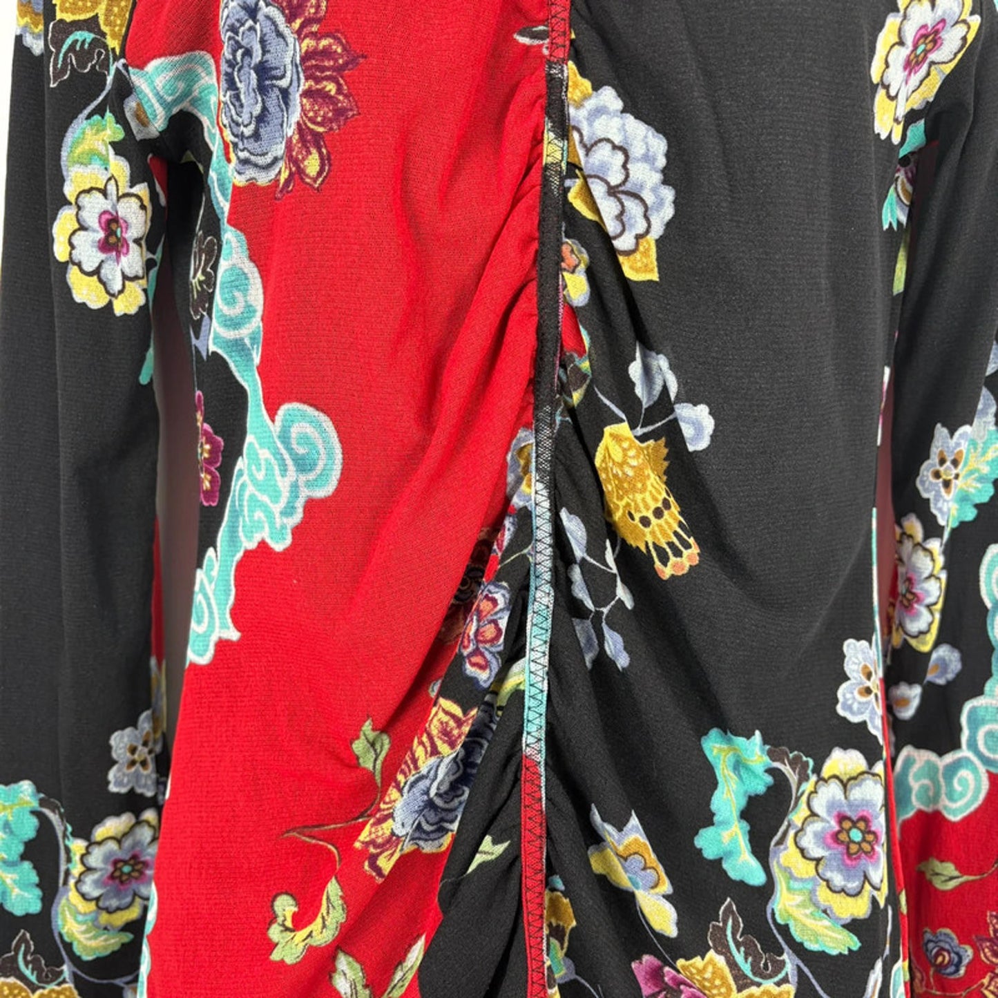 Close-up of a colorful floral fabric with red, black, and multicolor patterns.