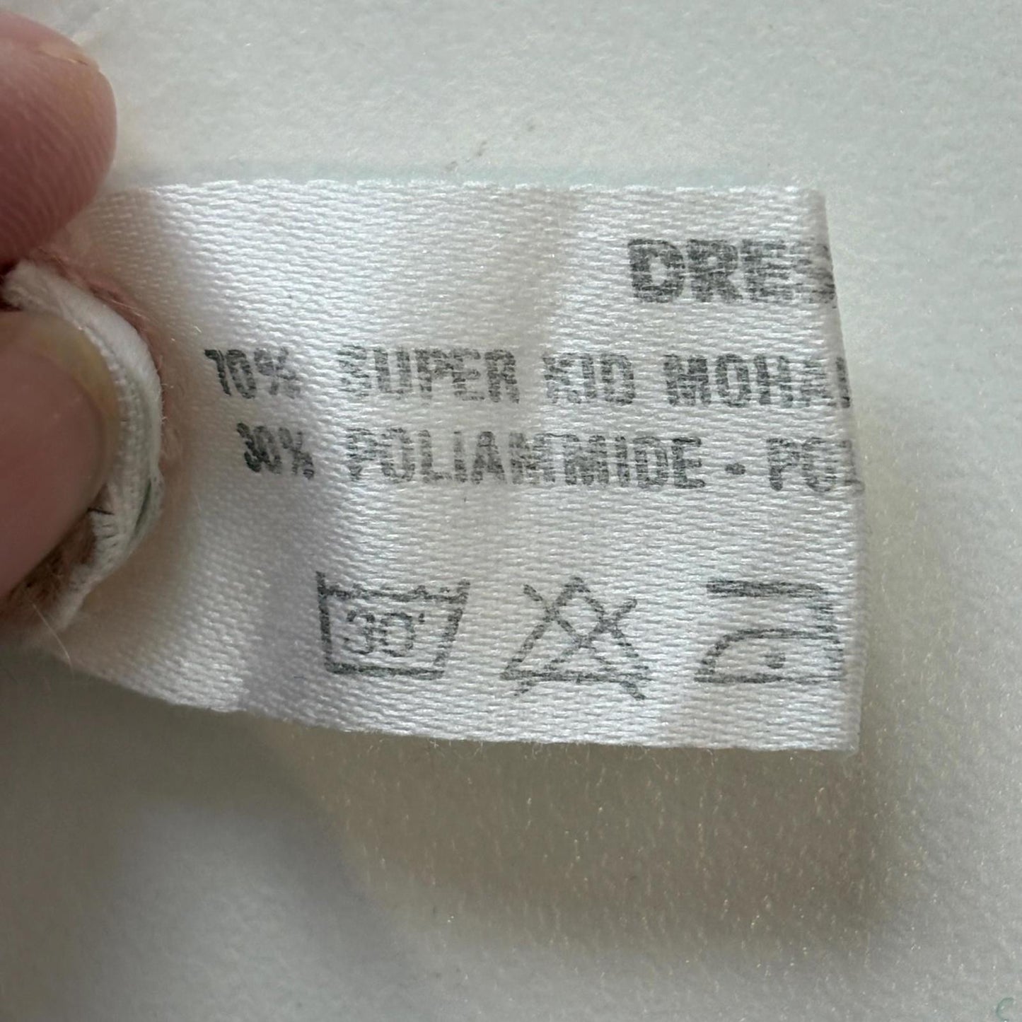Clothing label with fabric composition and care instructions on a white background