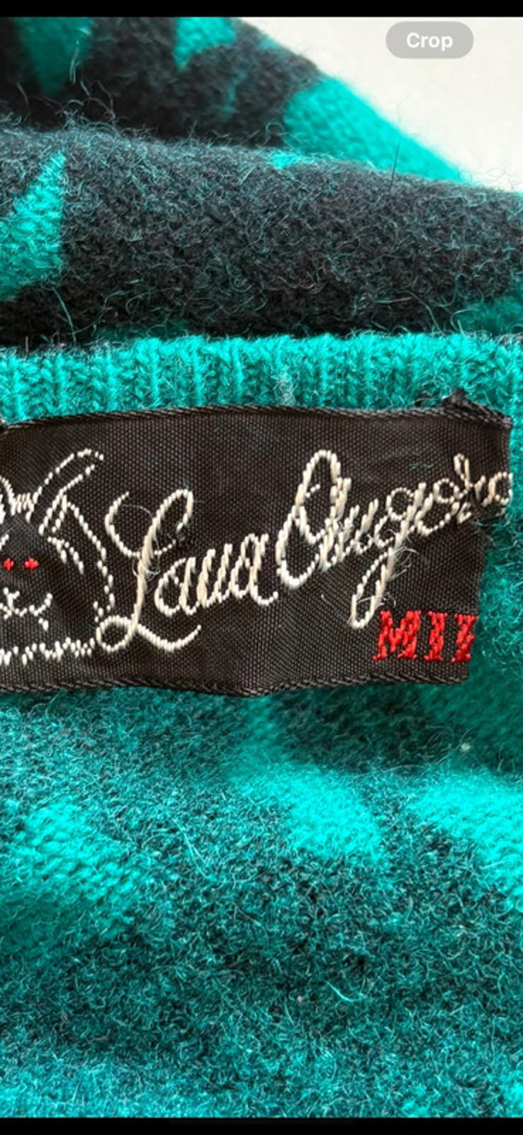 Close-up of a teal textured fabric with a branded label.