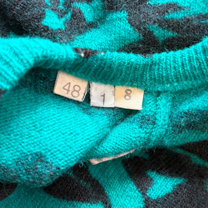 Close-up of a teal fabric with size tags on a floral background