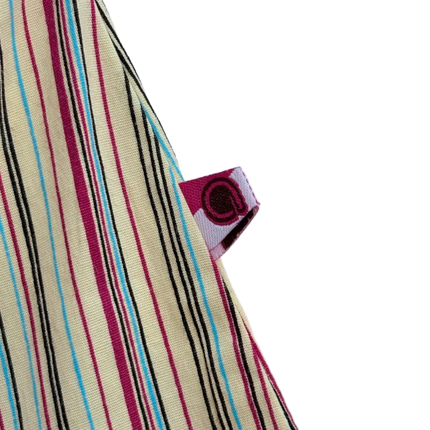 Close-up of a striped fabric with a label against a light blue background