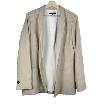 Beige blazer on a hanger against a white background