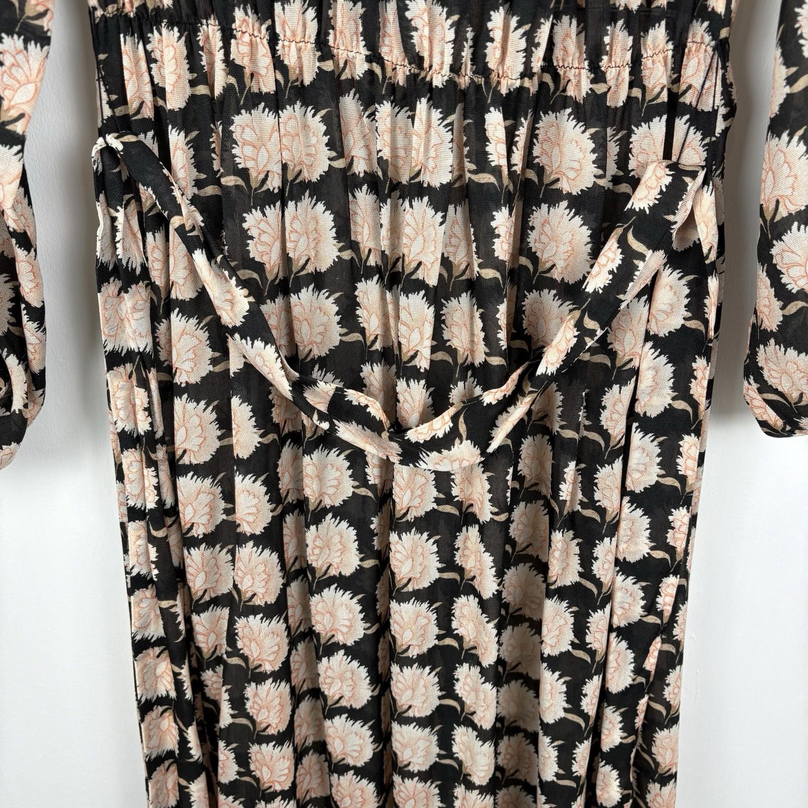 Floral patterned fabric with black, beige, and white colors on a white background