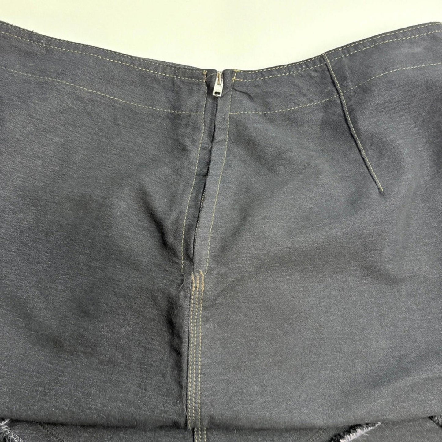 Close-up of gray pants with a zipper on a white background