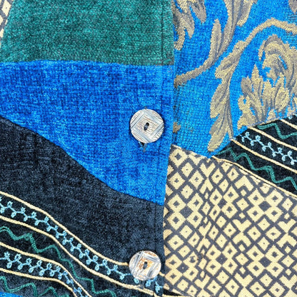 Close-up of a fabric with intricate patterns and buttons on a blue and black background