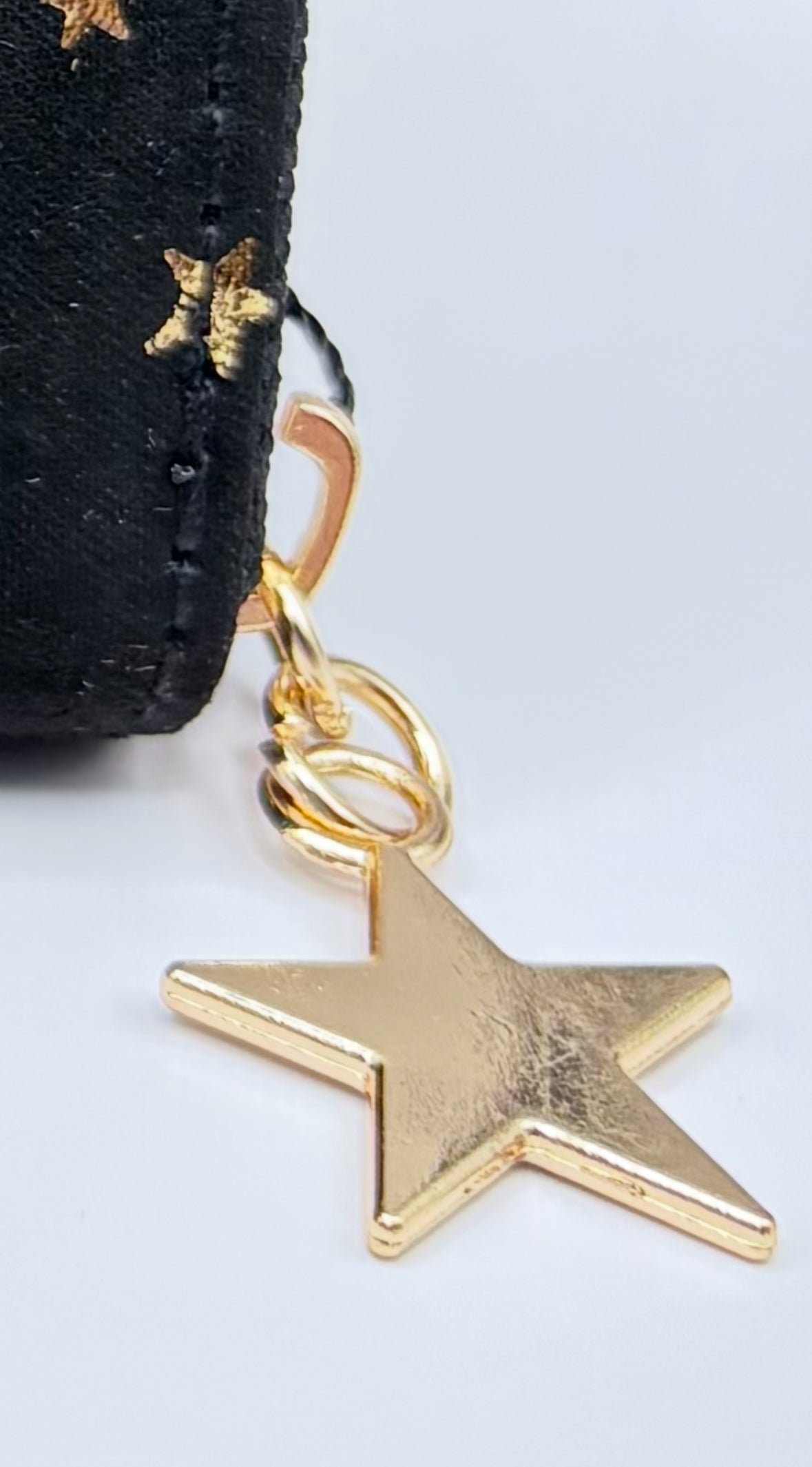 Gold star charm on a black background